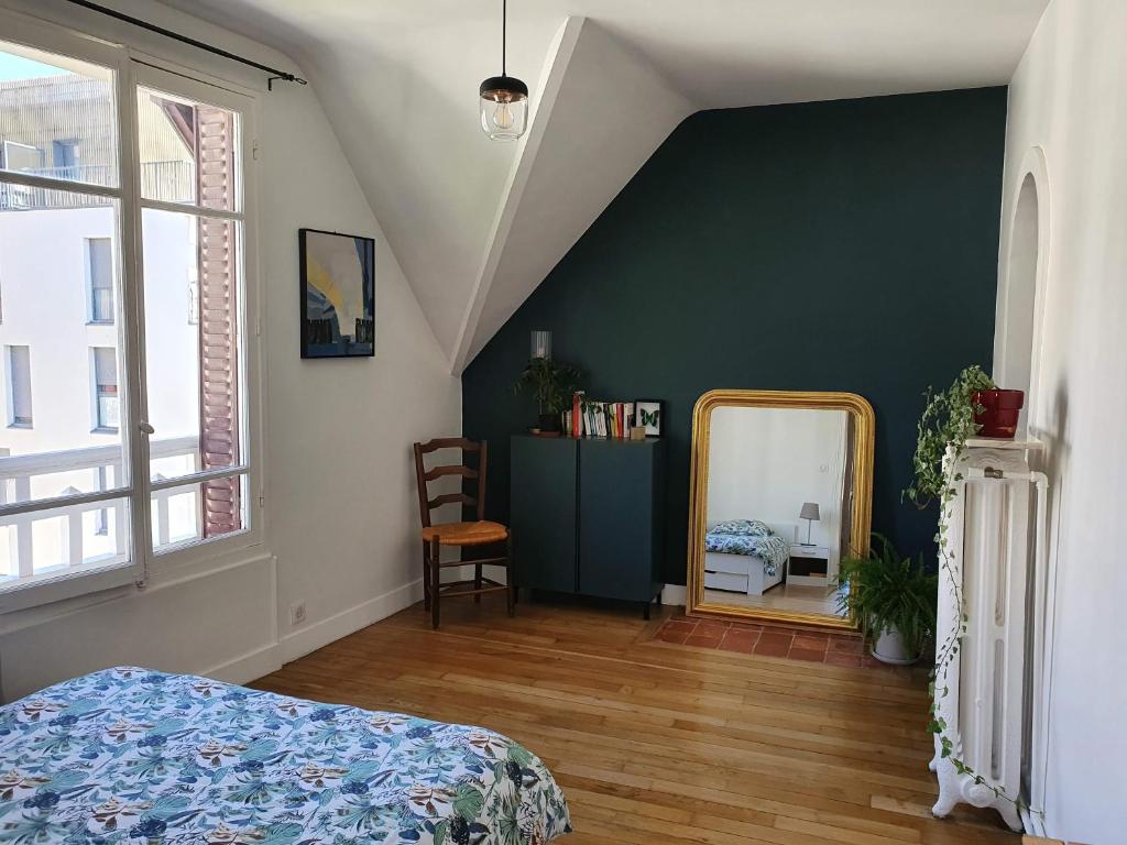 昂吉安班斯2 chambres dans une maison proche de Paris et du Stade de France的一间卧室设有绿色的墙壁和镜子