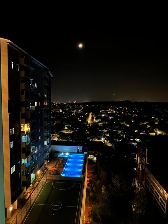 雪邦Ilsham Guest House @ Seroja Hills BBST Sepang的建筑在晚上可欣赏到城市美景