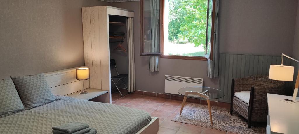 韦尔东河畔拉帕吕B&B Auberge Verdon的一间卧室配有一张床、一张桌子和一个窗户。