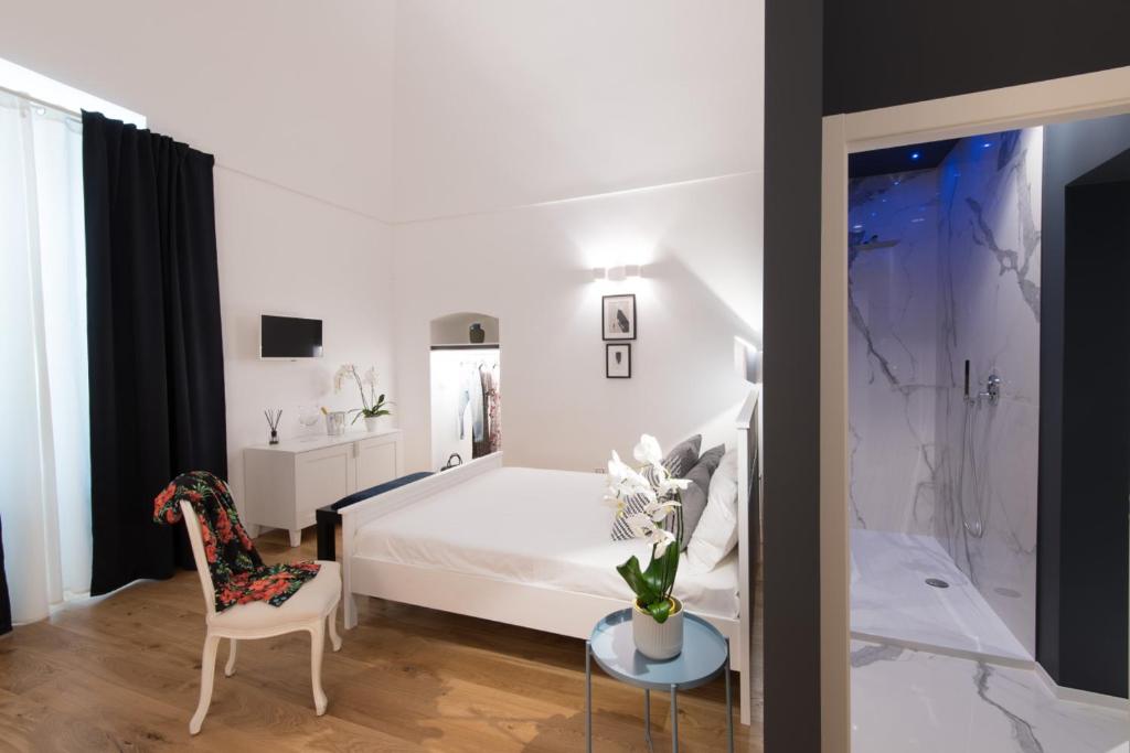 特拉尼I Colori della Puglia Rooms的卧室配有1张床、1张桌子和1把椅子