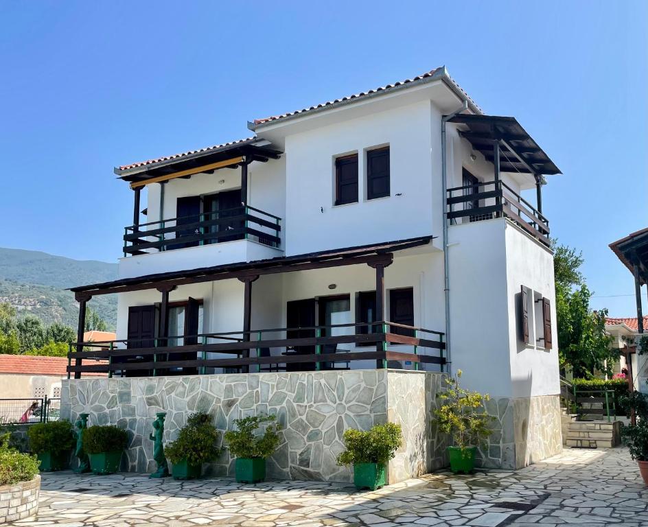 卡拉内拉Anemos Pelion Seaview的带阳台和盆栽植物的白色房屋