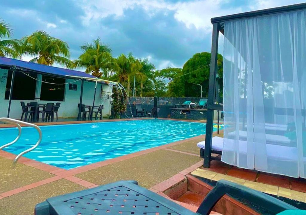 比亚维森西奥Llano Dorado Hotel Campestre的一个带庭院和房子的游泳池