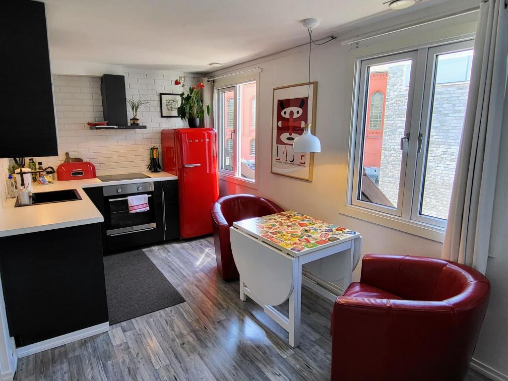 斯塔万格Cozee Central Apartments的厨房配有桌子和红色冰箱
