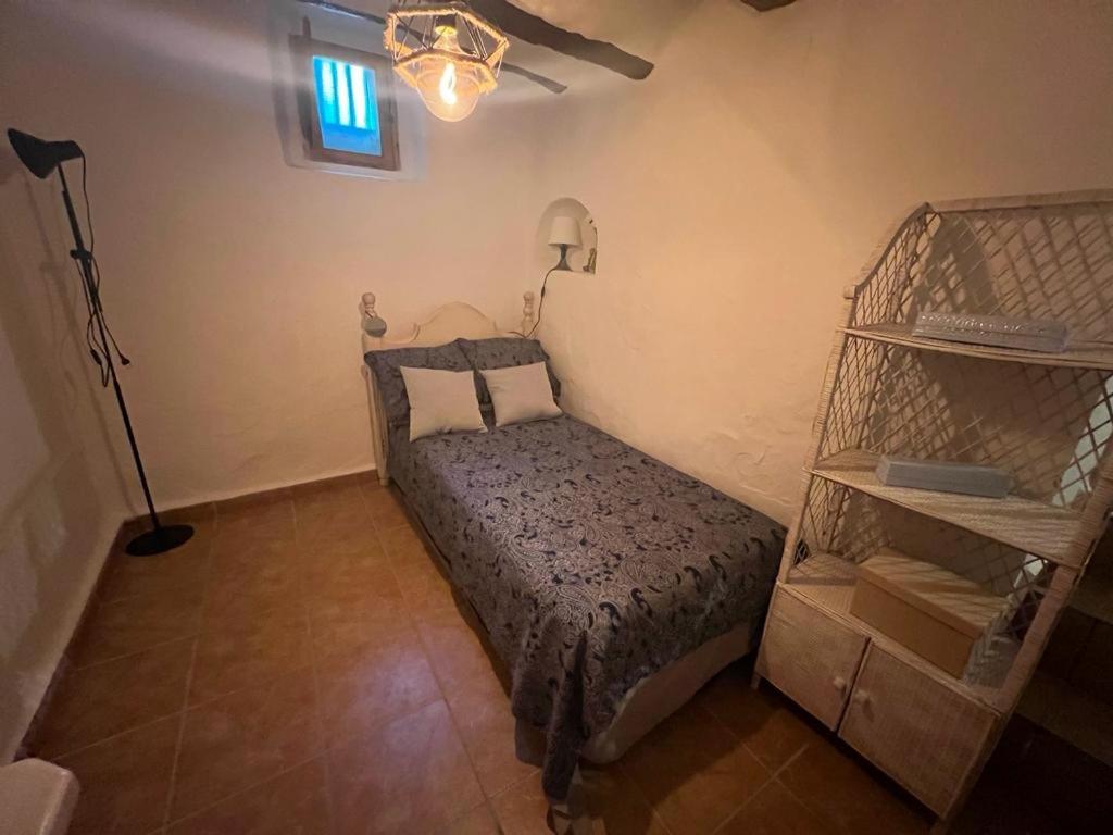 ZarraCasa rural El encanto的一间卧室配有床、灯和架子