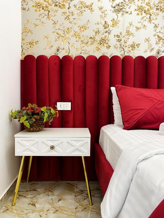 埃里温Shirbakyan Boutique Hotel & Apartments的卧室里红色的垫子墙,配有一张床