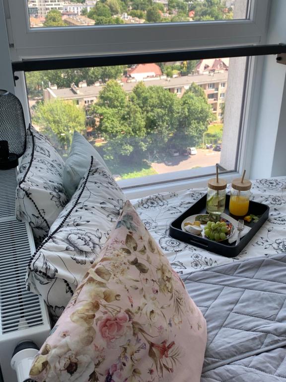 克拉科夫Panorama View of Krakow的窗户前的一张带枕头的床和食品托盘