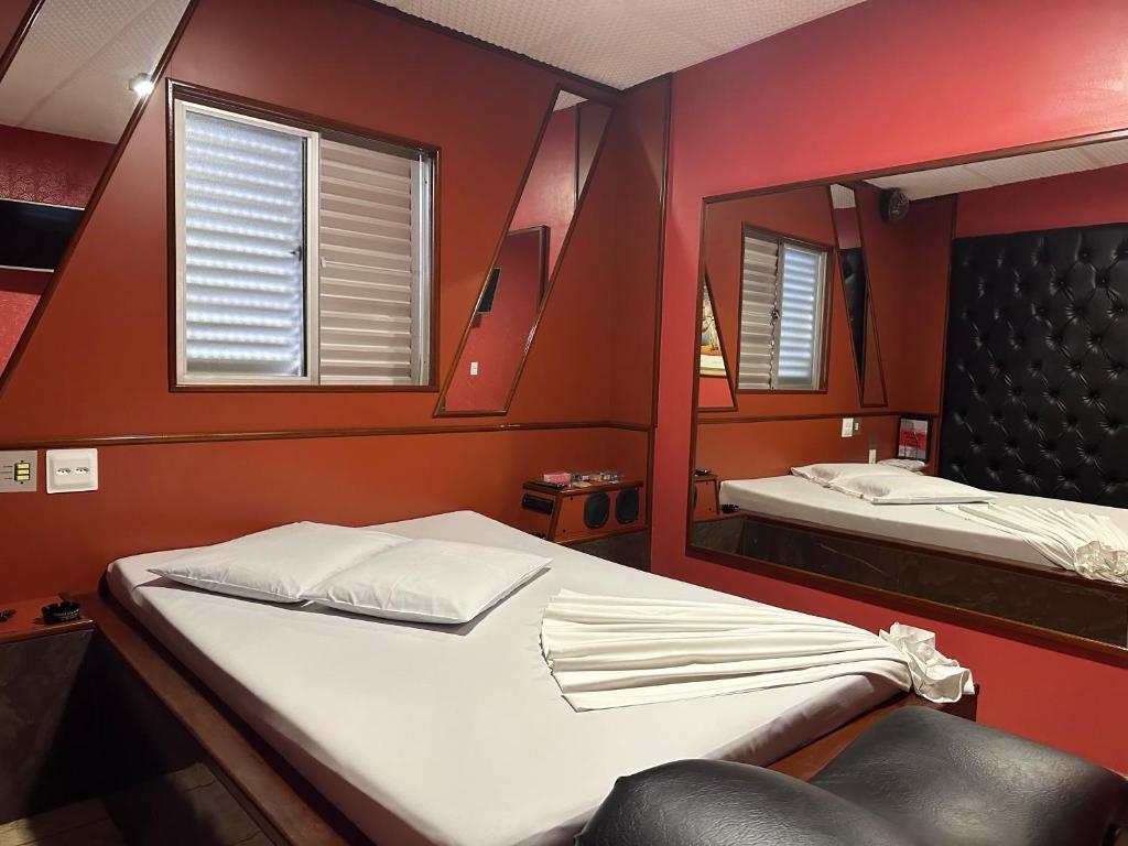 贝洛奥里藏特Motel Cigano’s的小房间设有床和镜子