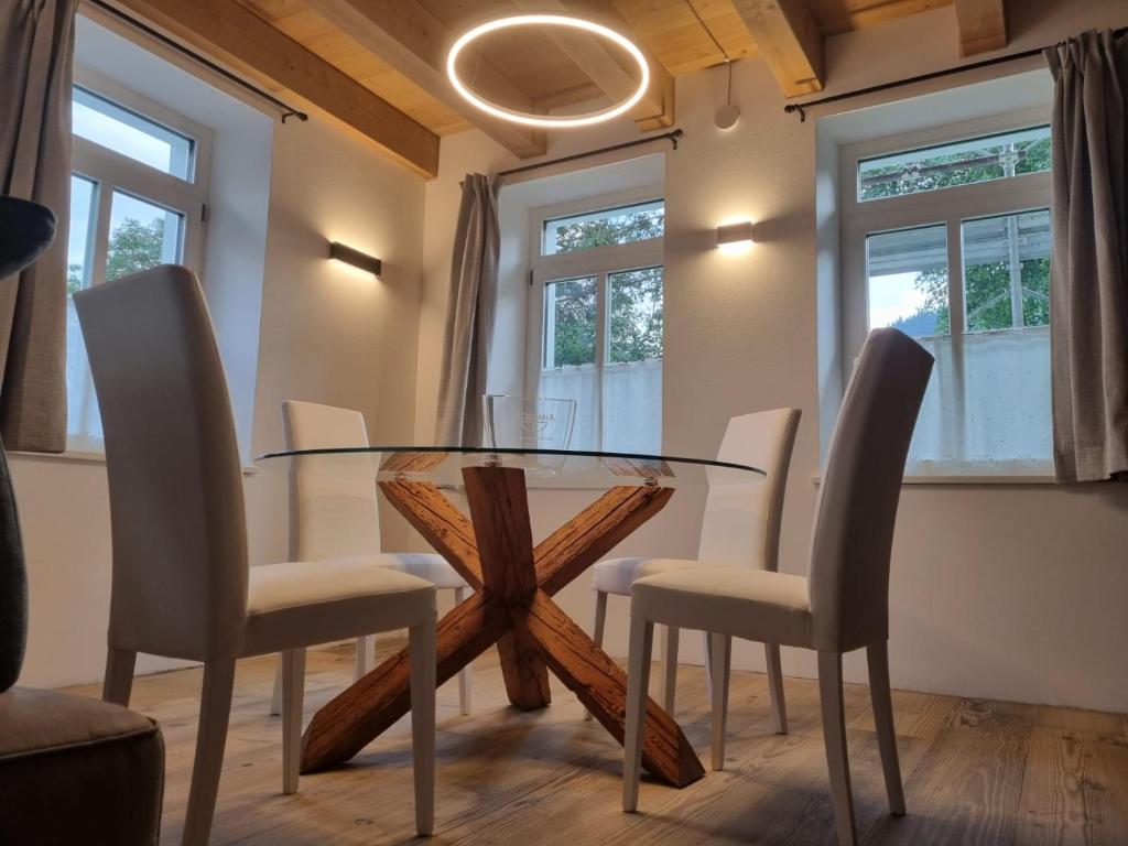 圣维托-迪卡多雷Appartamento Vale e Schena Cortina D'Ampezzo的一间设有玻璃桌和椅子的用餐室