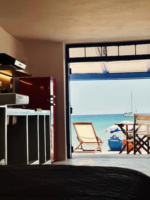 ProvatasCave Beach House Milos的享有海滩景致的客房,配有桌椅