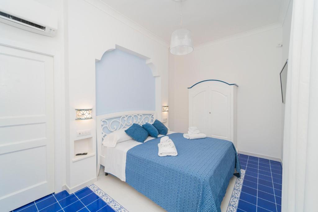 马奥莱Relais Capitolo的一间铺有蓝色和白色瓷砖的卧室