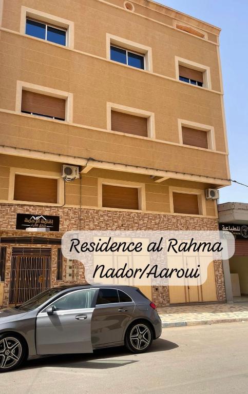 Monte ʼArrouitResidence al Rahma 05的停在大楼前的汽车