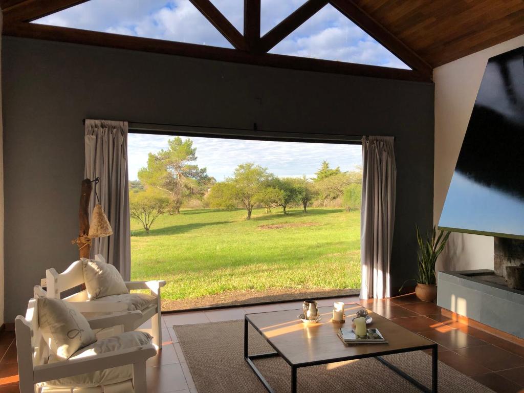 La Recompensa House的客厅设有大窗户,享有田野美景