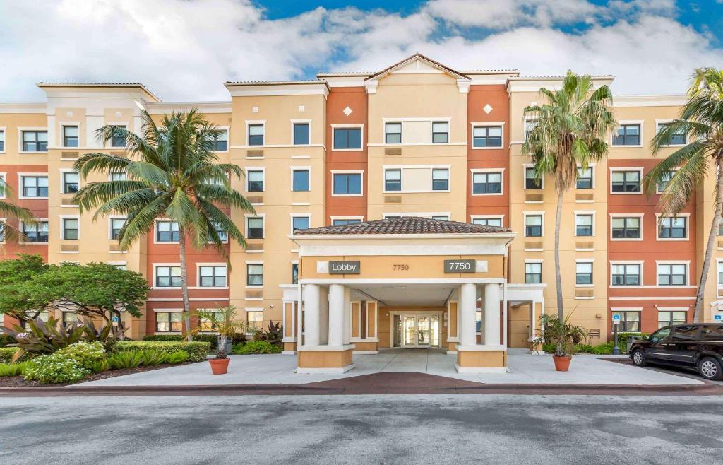 迈阿密Extended Stay America Premier Suites - Miami - Airport - Doral - 25th Street的一座棕榈树环绕的大建筑