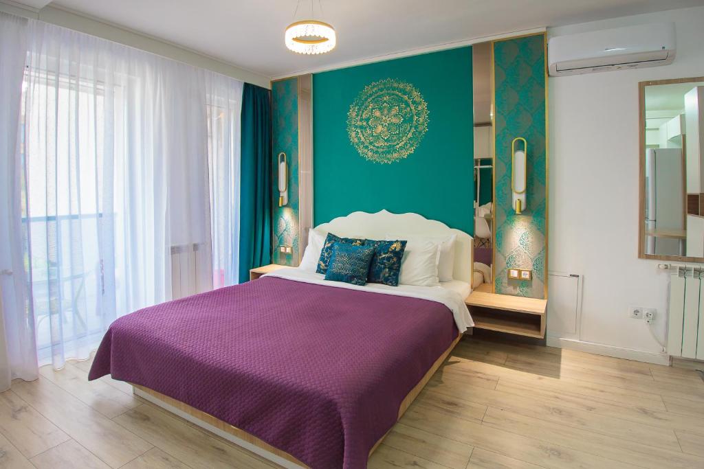 克卢日-纳波卡Gold Class Apartments AMS的一间卧室配有一张大床和紫色毯子