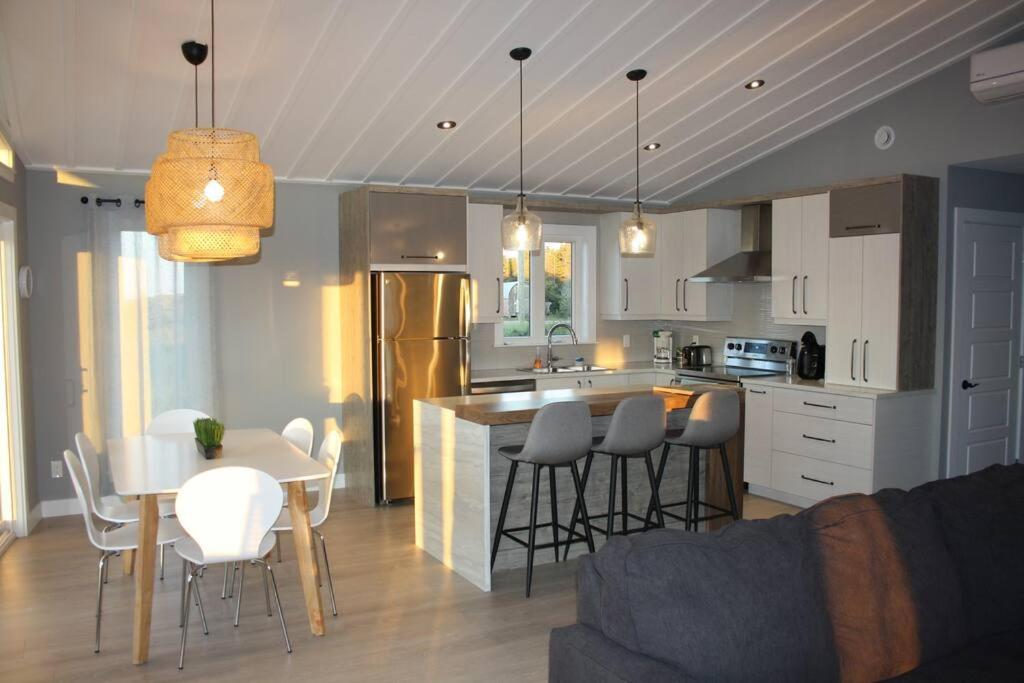 卡拉凯特Luxueux chalet sur la plage - Baie des Chaleurs的厨房以及带桌椅的起居室。