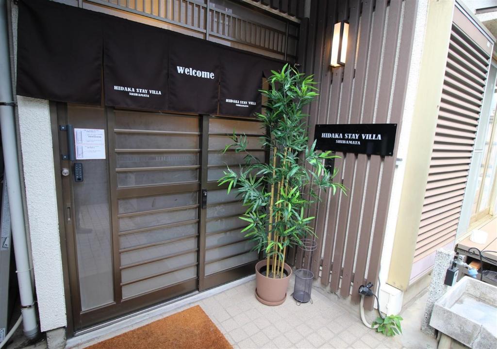 东京HIDAKA STAY VILLA 柴又的前面有两棵植物的车库门