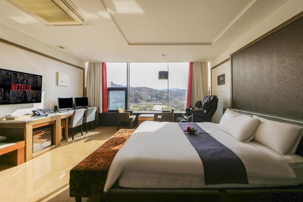 顺天市Ambassador Hotel的酒店客房设有一张大床和一张书桌。