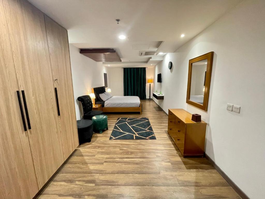 拉合尔AirReside Hotel Apartments Gold Crest的走廊上设有一张床和一张书桌的房间