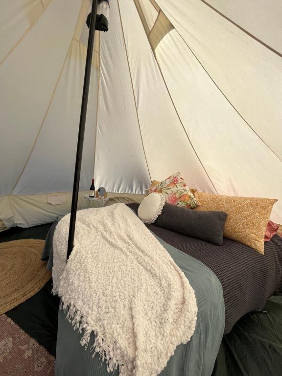 亚拉腊Cosy Glamping Tent 3的一张带白色毯子的床和一个帐篷