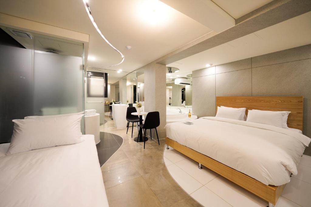 首尔SimpleStay Hotel in Jongno的酒店客房配有两张床和一张书桌
