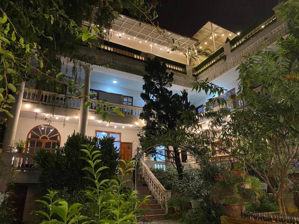 胡志良Nắng Hiên Nhà Villa - Homestay Đà Lạt的一座带庭院的建筑,庭院里种有植物和灯光