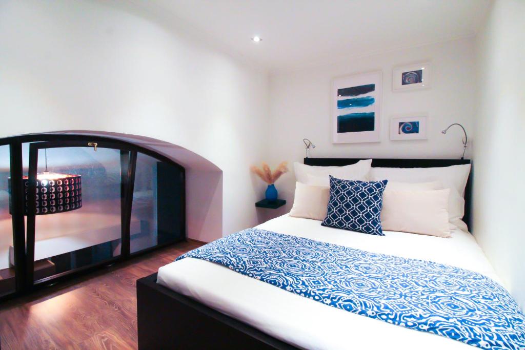 布达佩斯Budapest Downtown Museum Apartments的一间卧室配有一张带蓝白色枕头的大床