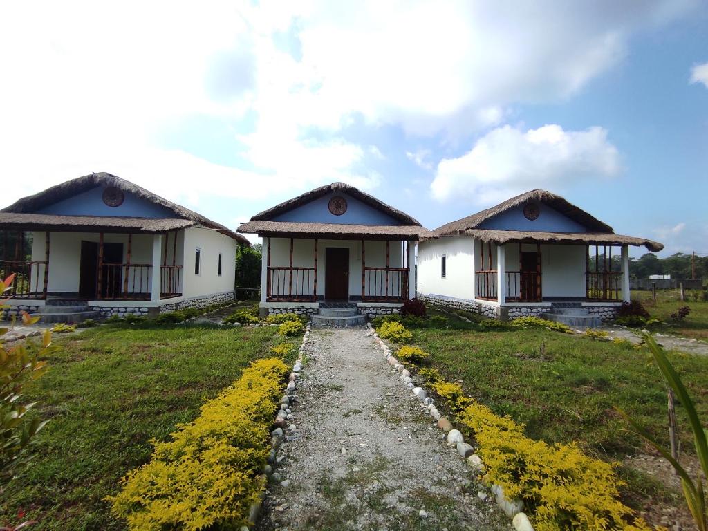 Jyoti GaonFalcon Jungle Resort的两栋白色房屋,有草地庭院