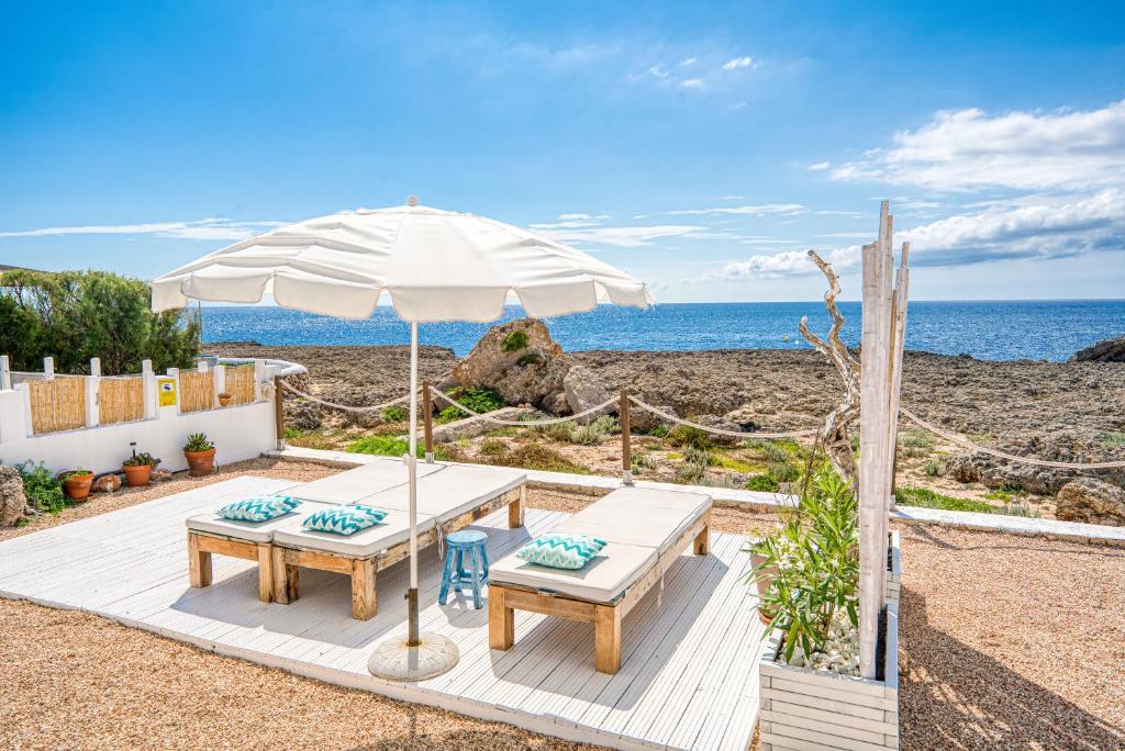 卡拉布兰卡Mar i Vent的海滩上的野餐桌和遮阳伞