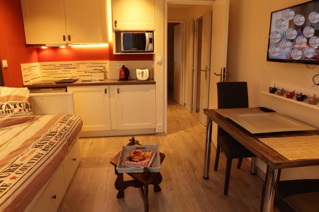 南特博纳维尔小屋公寓的配有床和桌子的房间以及厨房