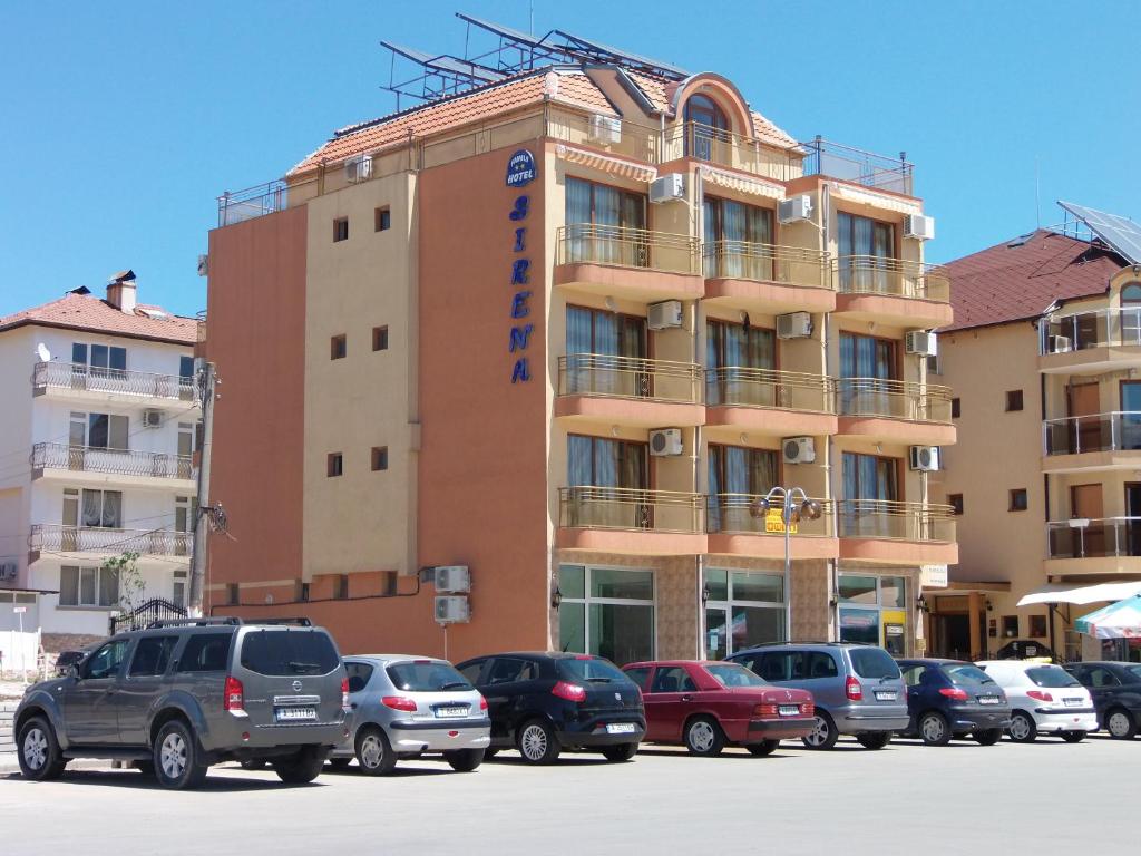 普里莫尔斯科塞丽娜酒店的停车场内有车辆的建筑物