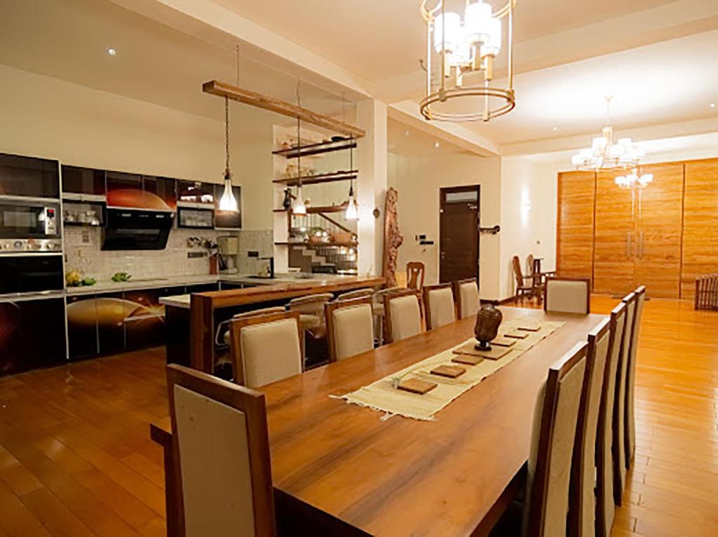 康提Royal Retreat Kandy的用餐室以及带大木桌的厨房。