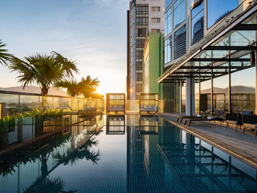 岘港Bay Capital Danang的一座建筑物中央的游泳池