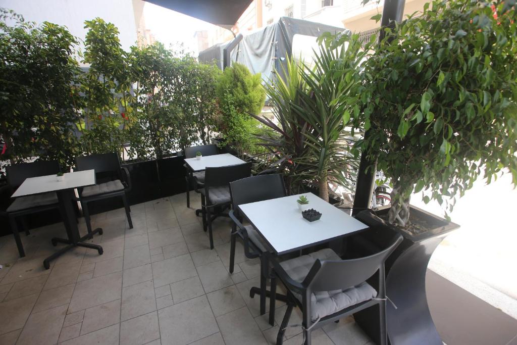 卡萨布兰卡LOTUS HOTEL Casanearshore的一个带桌椅和盆栽的庭院