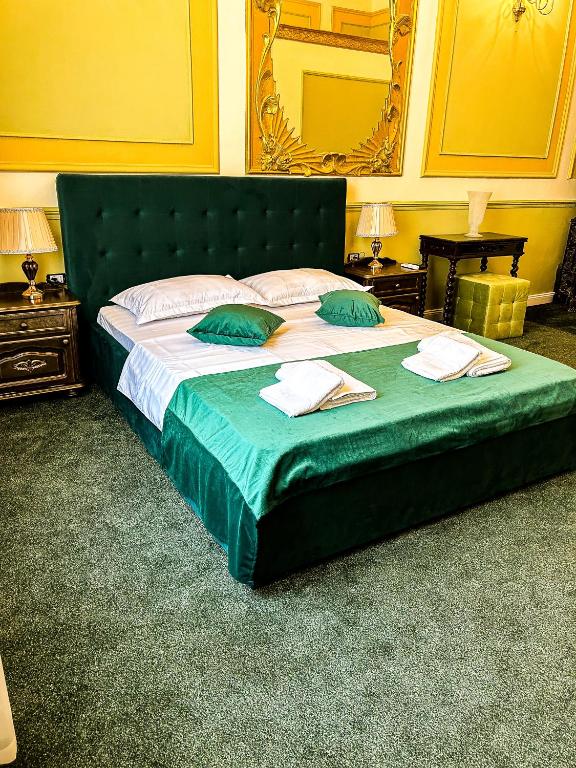 布加勒斯特Hotel Boutique Casa Vermont的一张带两个绿色枕头的大型绿床
