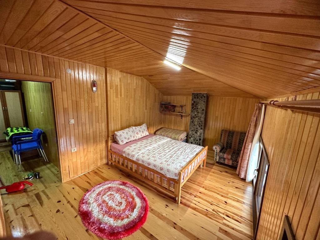 Çaykaraأوزونغول Uzongol Fotinos Wooden Cottage Two Bedroom的木制客房内的一间卧室,配有一张床