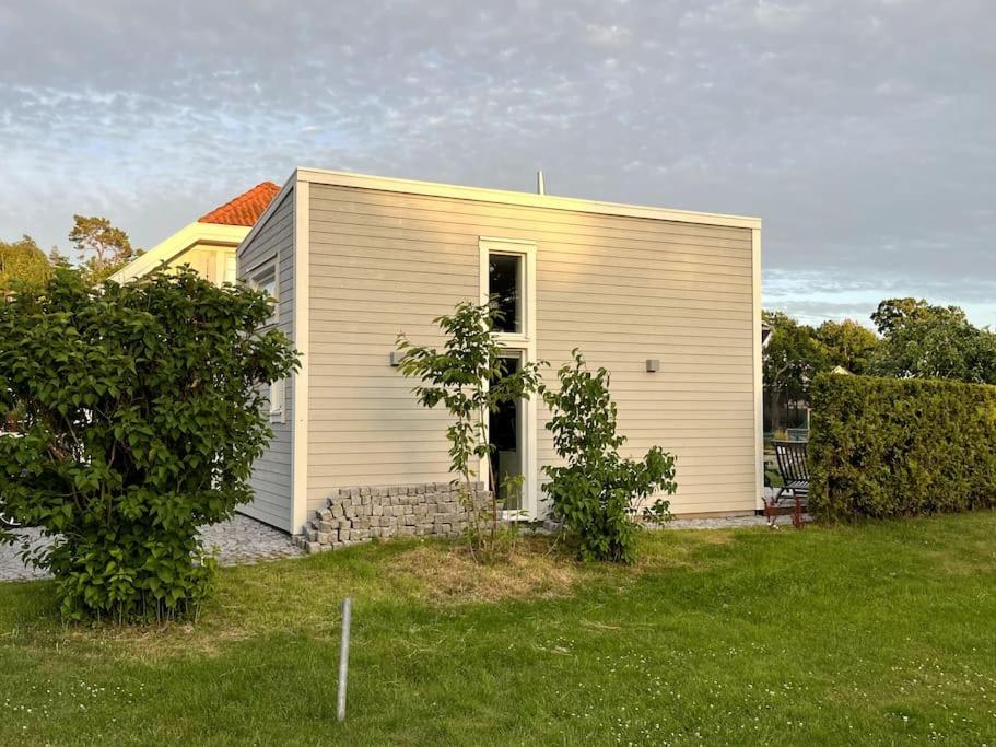 KullavikNybyggt gästhus nära havet och Göteborg的田野上的白色小房子,有院子