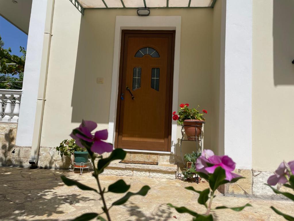 萨兰达Miranda's Apartments & Rooms的门前有鲜花的房子的门