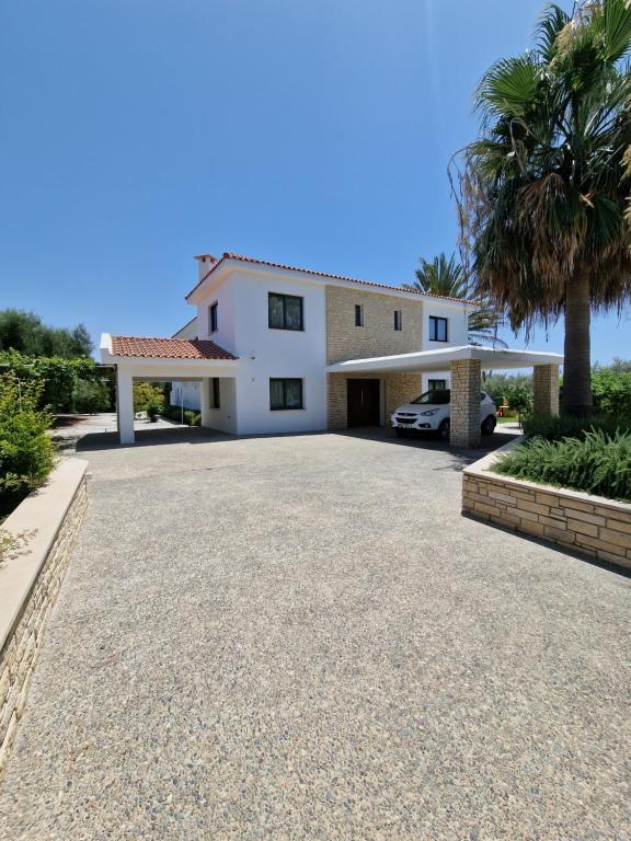 PaphosLuxury 6 bedrooms villa in Cyprus的前面有车道的房子