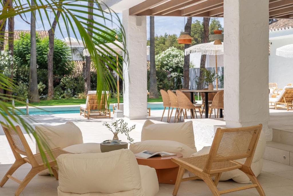 马贝拉Anfitrión Villas & Suites的一个带桌椅的庭院和一个游泳池