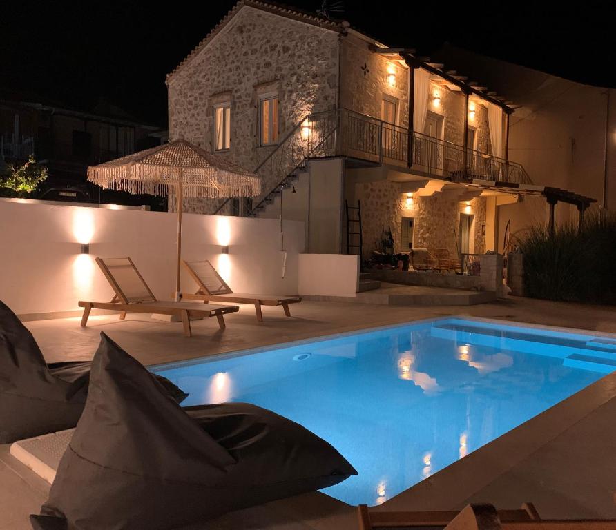梅加尼西岛Mangata suites homes with private pools的夜间在房子前面的游泳池