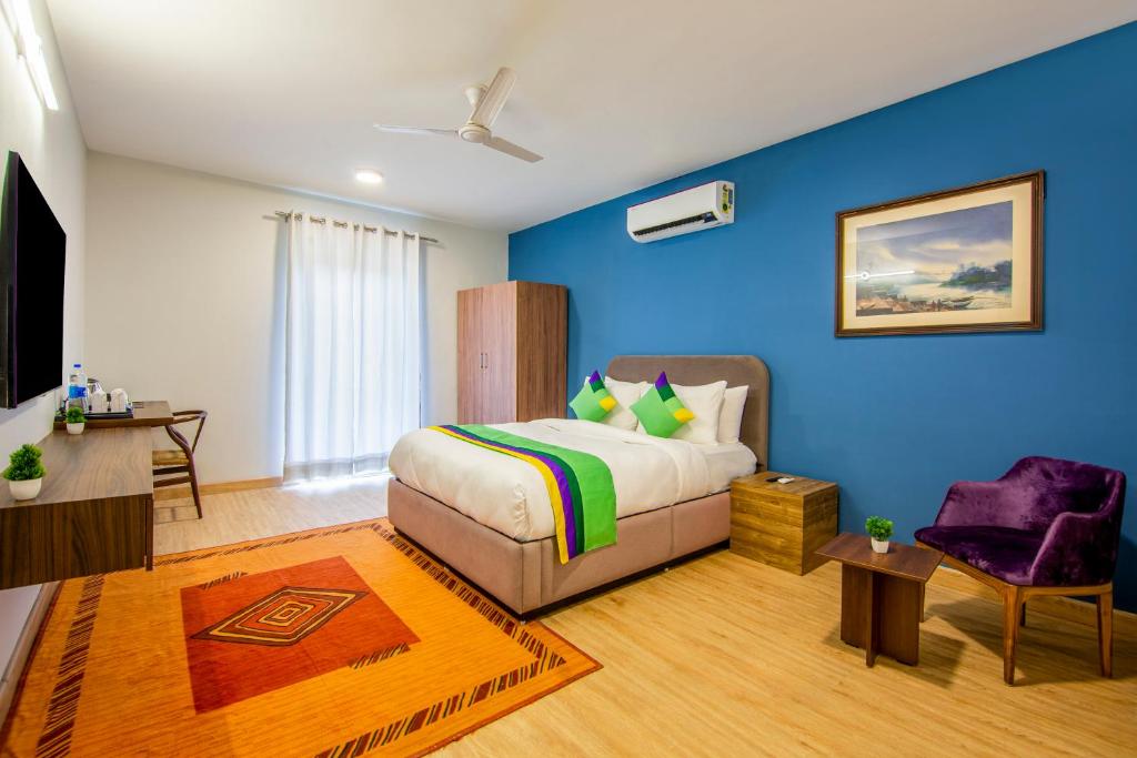 古尔冈Treebo Trend Jass Hospitality Services Sec 53的一间卧室设有一张床和蓝色的墙壁