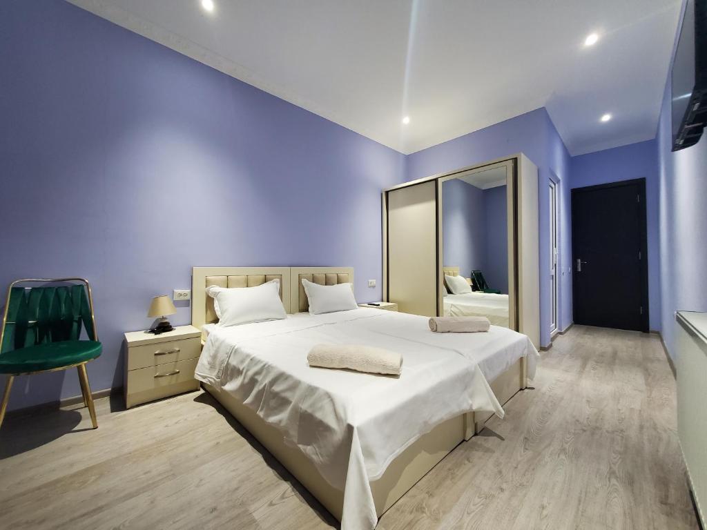 茨卡尔图博Hotel N的一间蓝色的卧室,配有一张大床和镜子