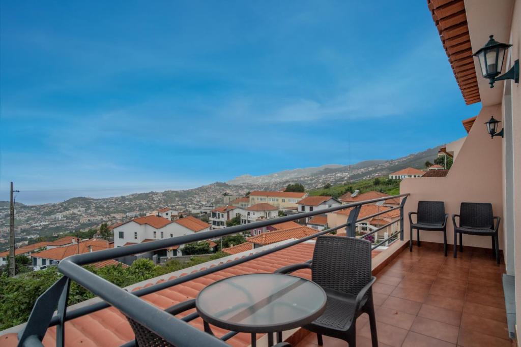 丰沙尔Casa Monte的设有一个配有桌椅并享有美景的阳台。