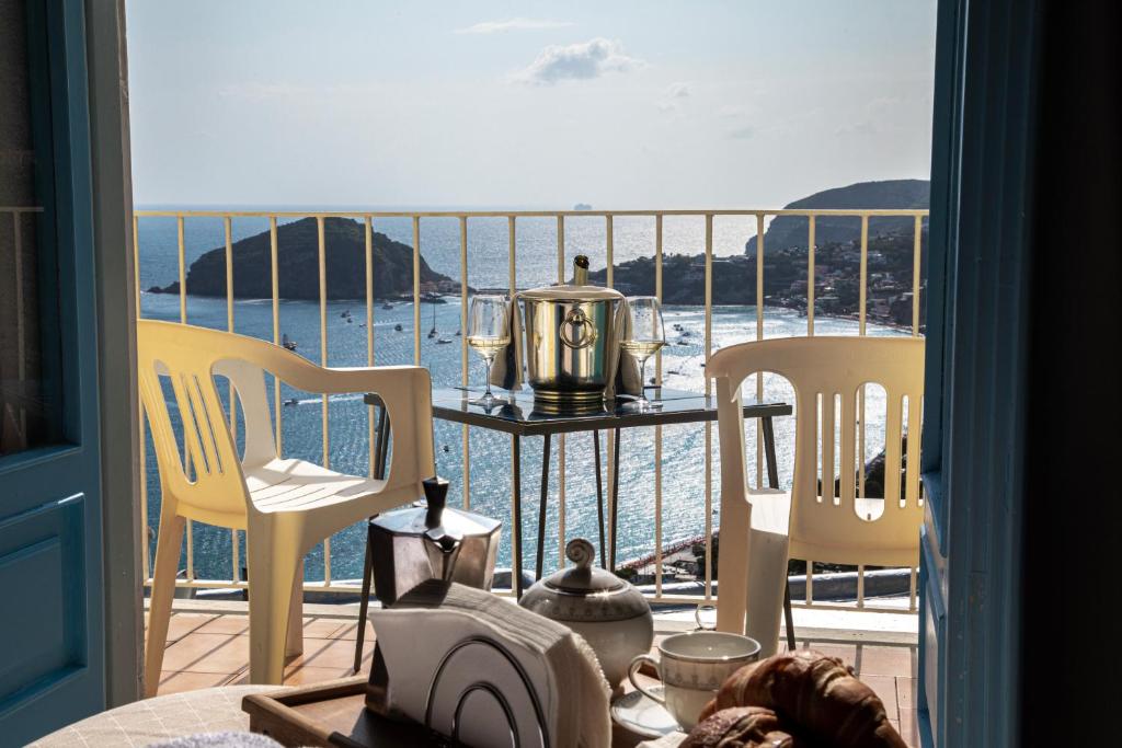 伊斯基亚Hotel Sunset Green的阳台配有两把椅子和一张桌子,享有海景。