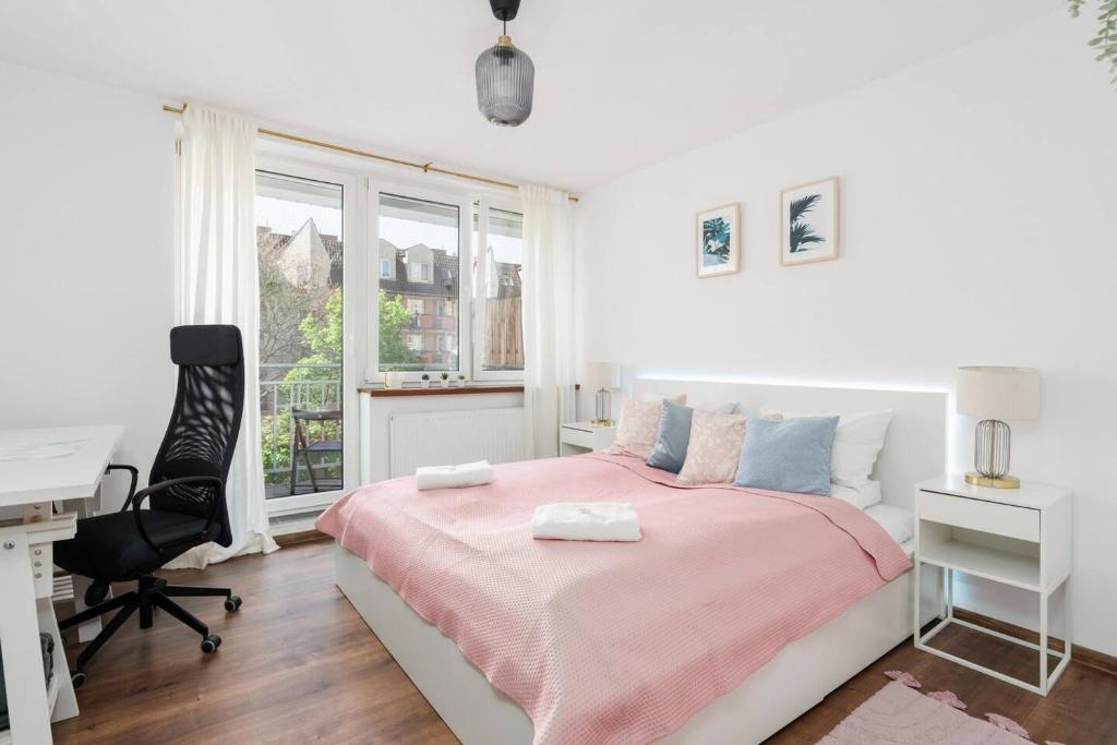 波兹南Kosińkiego Apartament Poznań by Renters的白色卧室配有粉红色的床和书桌
