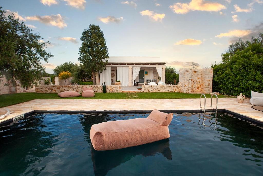 孔韦尔萨诺Casa mia in Puglia的庭院中间带椅子的游泳池