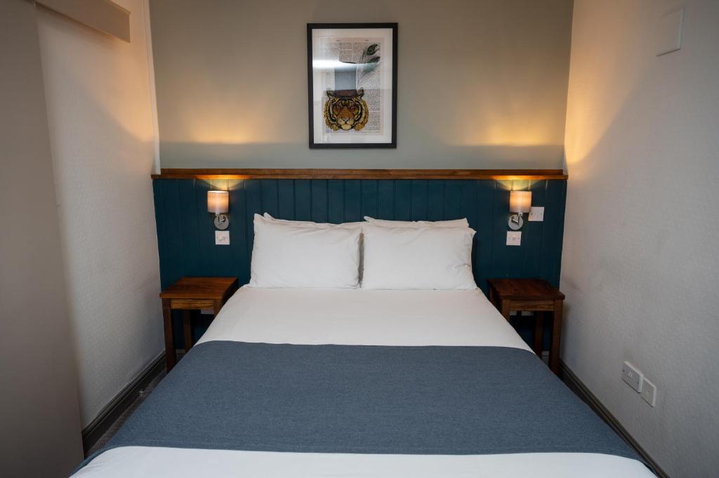 考文垂Cocked Hat by Greene King Inns的一间卧室配有一张蓝色床头板的床