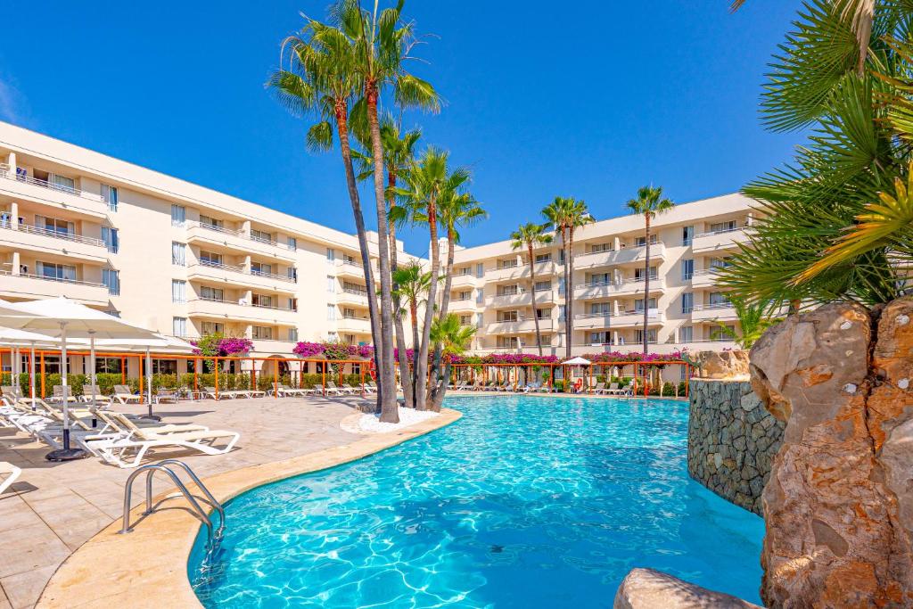 萨科马Hotel Rosella affiliated by Intelier的棕榈树游泳池以及酒店