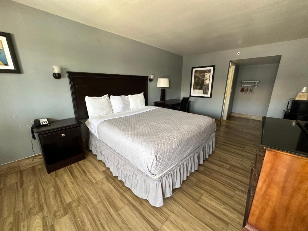 圣安东尼奥HillView Inn at Six Flags Fiesta的酒店客房配有一张床铺和一张桌子。