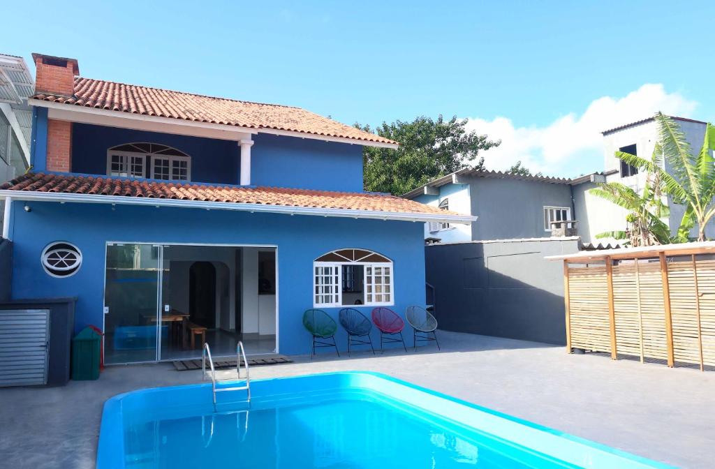 弗洛里亚诺波利斯Sea Wolf Hostel - Lagoa da Conceição的蓝色的房子,前面设有一个游泳池